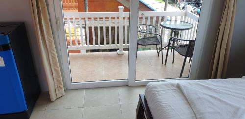 a bedroom with a door open to a balcony with a table at Moon Travel Phangan in Ban Nua