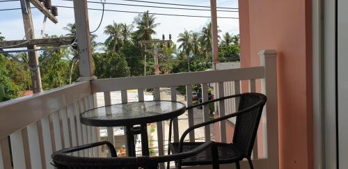 a table and two chairs on a balcony at Moon Travel Phangan in Ban Nua
