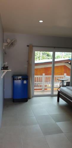 a living room with a large sliding glass door to a balcony at Moon Travel Phangan in Ban Nua