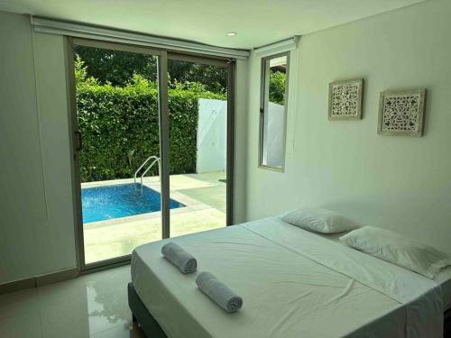 a bedroom with a bed and a swimming pool at Hermosa Casa Campestre Con Piscina y Bar 