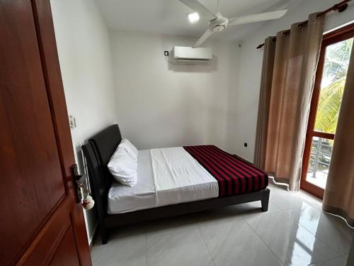 a small bed in a room with a window at Bolgoda Lake Villa in Moratuwa