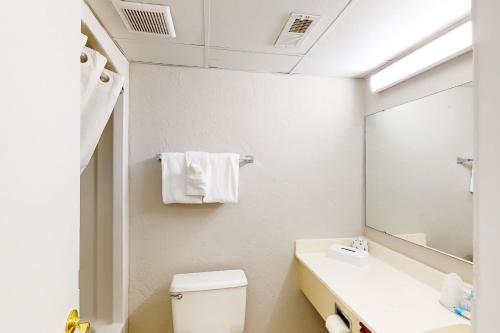 a bathroom with a toilet and a sink and a mirror at Ocean Park Resort 1222 in Myrtle Beach