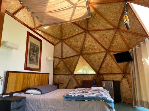 Habitación con cama en una pared de madera. en Treff Lodge Hotel en Oxapampa