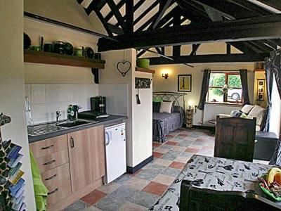 a kitchen and living room with a table and a couch at The Bothy in Malvern Wells