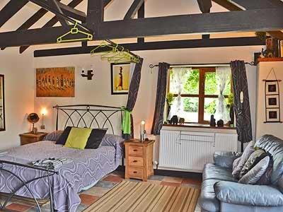 a bedroom with a bed and a couch at The Bothy in Malvern Wells