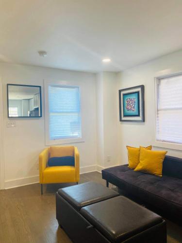 a living room with a couch and a yellow chair at Quaint 3/2.5 home in Fort Dupont in Washington