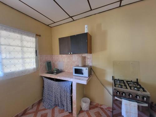 a small kitchen with a stove and a microwave at Chelox Panama Airport in Tocumen