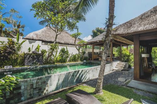 uma villa com uma piscina e uma casa em Luwak Estate em Ubud