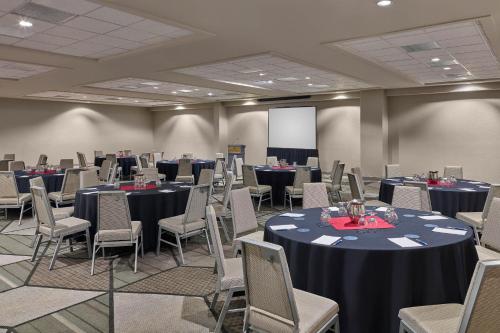 a conference room with tables and chairs and a screen at Sheraton Tucson Hotel & Suites in Tucson