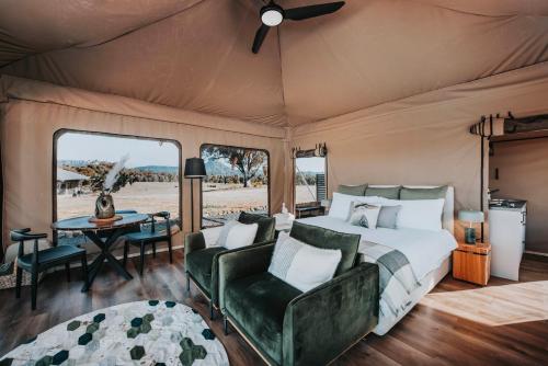 a bedroom in a tent with a bed and a table at Wildnest Farmstay in Capertee