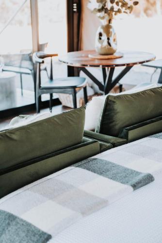 a bed with green and white pillows and a table at Wildnest Farmstay in Capertee