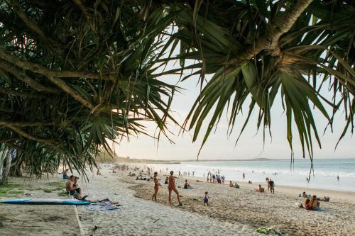 un groupe de personnes sur une plage avec l'océan dans l'établissement 71 Hastings Street - Beachfront, à Noosa Heads