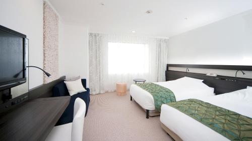 a hotel room with two beds and a flat screen tv at Hotel Granvia Osaka-JR Hotel Group in Osaka