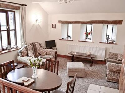 - un salon avec une table et des chaises dans l'établissement Gallaber Cottage, à Burton in Lonsdale