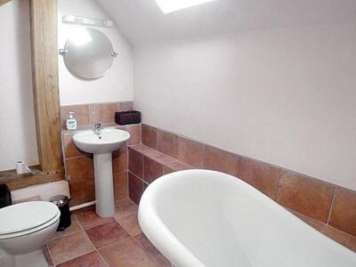 uma casa de banho com uma banheira, um WC e um lavatório. em The Old Carthouse em Steyning