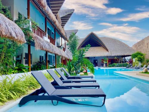 a row of lounge chairs next to a resort pool at Bathala Resort in Panglao