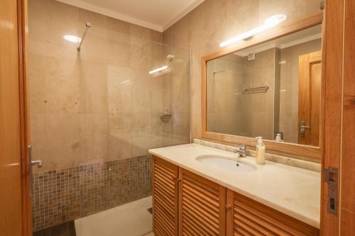 a bathroom with a sink and a mirror and a tub at Pedra do Jota in Porto Santo