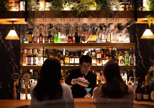 people sitting at a bar with a bartender at APA Hotel & Resort Osaka Umeda Eki Tower in Osaka