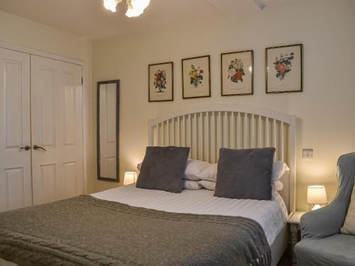 a bedroom with a bed with two pillows and a chair at Kingsway Apartment in Langstone