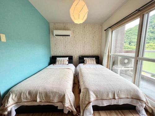 two beds in a room with a window at Fu days Condominium Jozankei / Vacation STAY 1657 in Sapporo