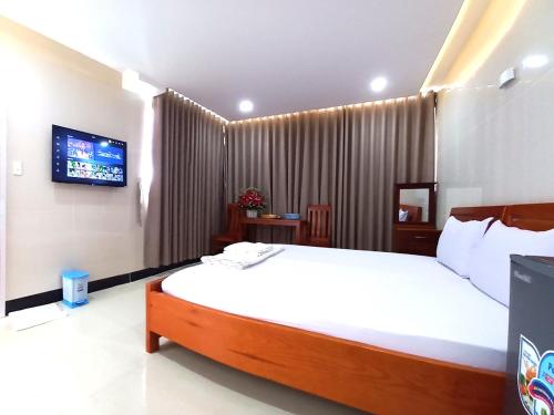 una camera con un grande letto e una TV di KHÁCH SẠN CÚC PHƯƠNG (CÚC PHƯƠNG HOTEL) a Dĩ An