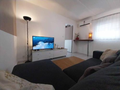 a living room with a couch and a flat screen tv at Leili Home - Papeete in Papeete