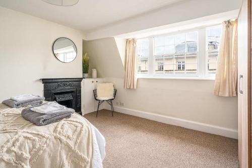 a bedroom with a bed and a mirror and a chair at Beautiful Character 3 Bed City Centre Apartment in Bath
