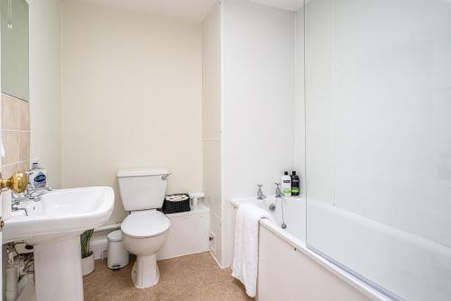 uma casa de banho branca com um lavatório, um WC e uma banheira em Beautiful Character 3 Bed City Centre Apartment em Bath