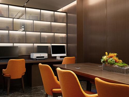 a conference room with a table with chairs and a computer at Hampton by Hilton Guangzhou Railway Station in Guangzhou