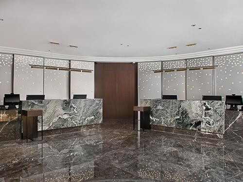 a lobby with a conference room with tables and chairs at Hampton by Hilton Guangzhou Railway Station in Guangzhou