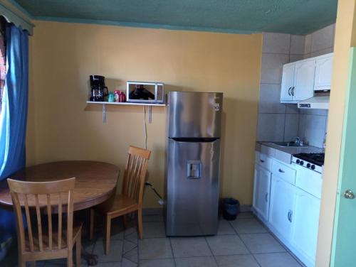 a kitchen with a table and a stainless steel refrigerator at Departamento #8 in San Felipe