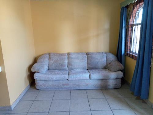 a couch in a living room with blue curtains at Departamento #8 in San Felipe