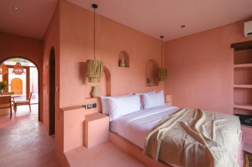 a bedroom with a large bed and a table at Villa Ella June in Canggu