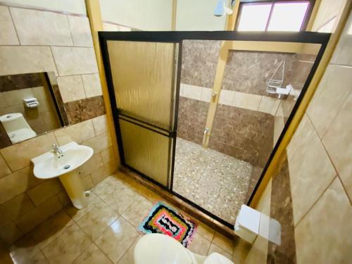a bathroom with a shower and a toilet and a sink at Arenal Jungla Lodge in San Ramón