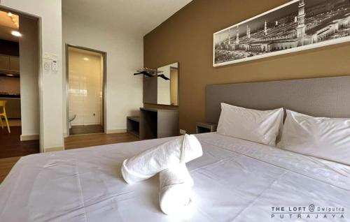 a bedroom with a large white bed with white pillows at THE LOFT@Dwiputra Putrajaya. in Putrajaya