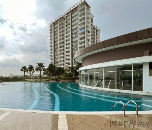 a building with a swimming pool in front of a building at THE LOFT@Dwiputra Putrajaya. in Putrajaya
