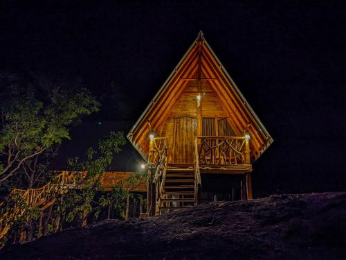 a wooden cabin with a staircase in the night at Sigiri Choona Lodge 'unique sunrise viewpoint' in Sigiriya