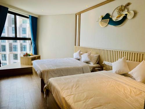 a hotel room with two beds and a window at Lighthouse Apec Mũi Né in Phan Thiet