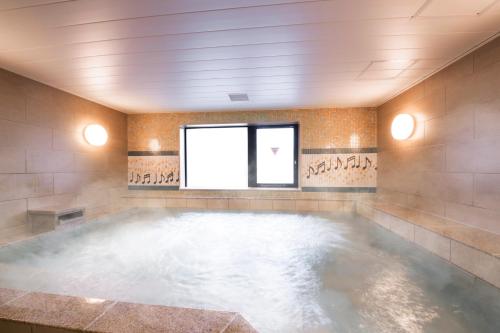 a large pool of water in a room with a window at Hotel Grand Bach Kyoto Select in Kyoto