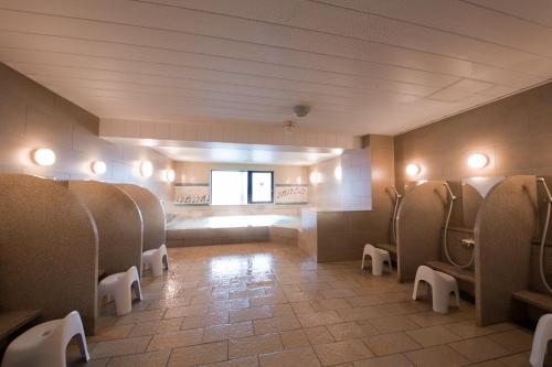 a bathroom with a row of urinals in a restroom at Hotel Grand Bach Kyoto Select in Kyoto