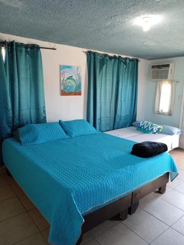 um quarto com uma cama grande e lençóis azuis em Departamento #11 em San Felipe