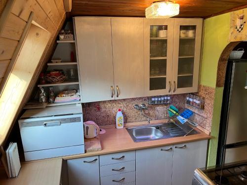 a small kitchen with white cabinets and a sink at Chata Sofie in Dolní Moravice