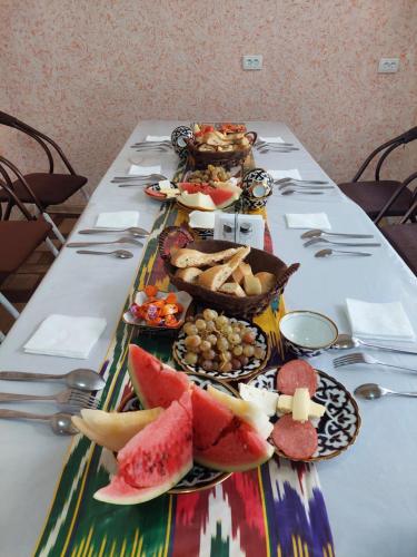 a table with plates of food on top at Hotel Sohibqiron Boutique in Bukhara
