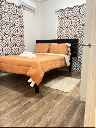 a bedroom with a bed with an orange blanket at Grey Stone Villa in Happy Hill