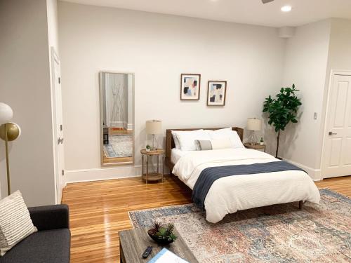 a bedroom with a large bed and a couch at Charming 1BD/1BA Studio; walk to stadiums & UMD in Baltimore