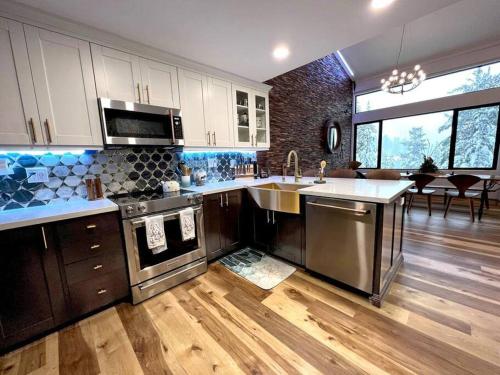 a large kitchen with stainless steel appliances and wooden floors at Gondola Chalet -New Luxury 5 Bdrm Condo @ Canyon Lodge, Steam Room in Mammoth Lakes