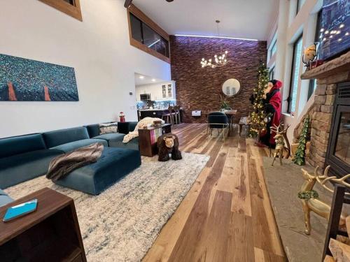 a living room with a blue couch and a fireplace at Gondola Chalet -New Luxury 5 Bdrm Condo @ Canyon Lodge, Steam Room in Mammoth Lakes