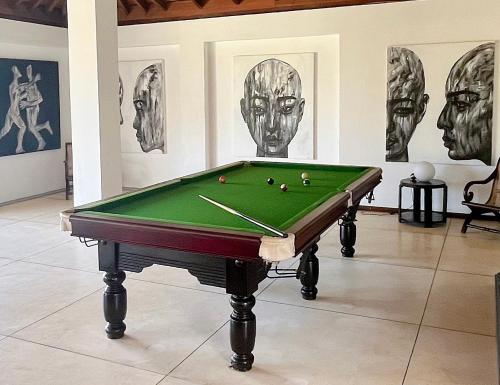 a pool table in a room with drawings on the wall at Elysium in Unawatuna