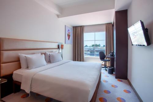a hotel room with a bed and a television at FOX HARRIS City Center Bandung in Bandung