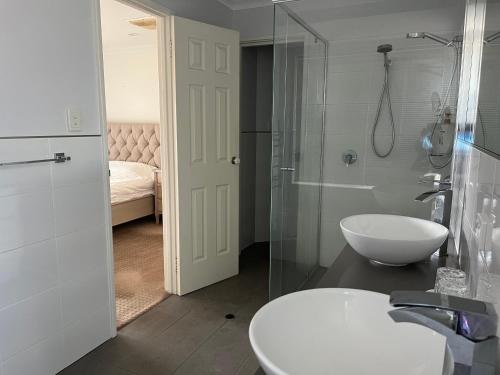 a bathroom with a sink and a glass shower at Applecross 2 Bedrooms by Swan River in Perth